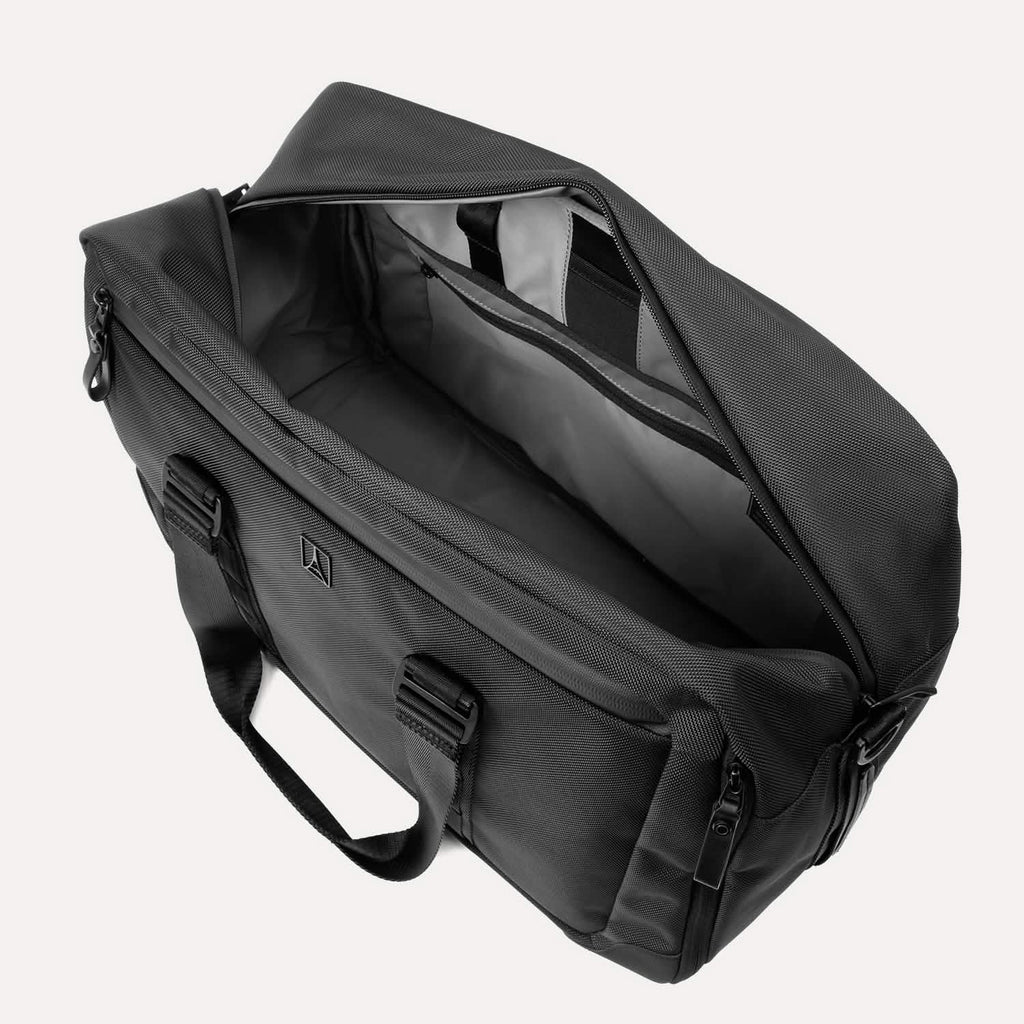 Slanted top view of Travelpro Altitude Double Expansion Duffel in Jet Black with open main compartment and interior pockets.
