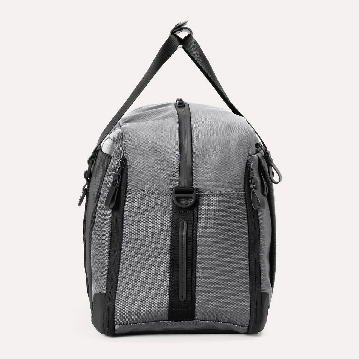 Side view of the Travelpro® Altitude™ Double Expansion Duffel in Falcon Grey, showing the vertical zippered pocket, top carry handle, and D-ring attachment point.