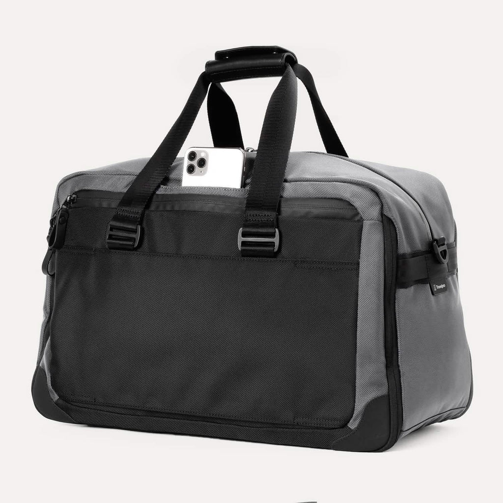 Slanted rear view of the Travelpro® Altitude™ Double Expansion Duffel in Falcon Grey, featuring a smartphone partially inserted into the top opening of the rear pocket.