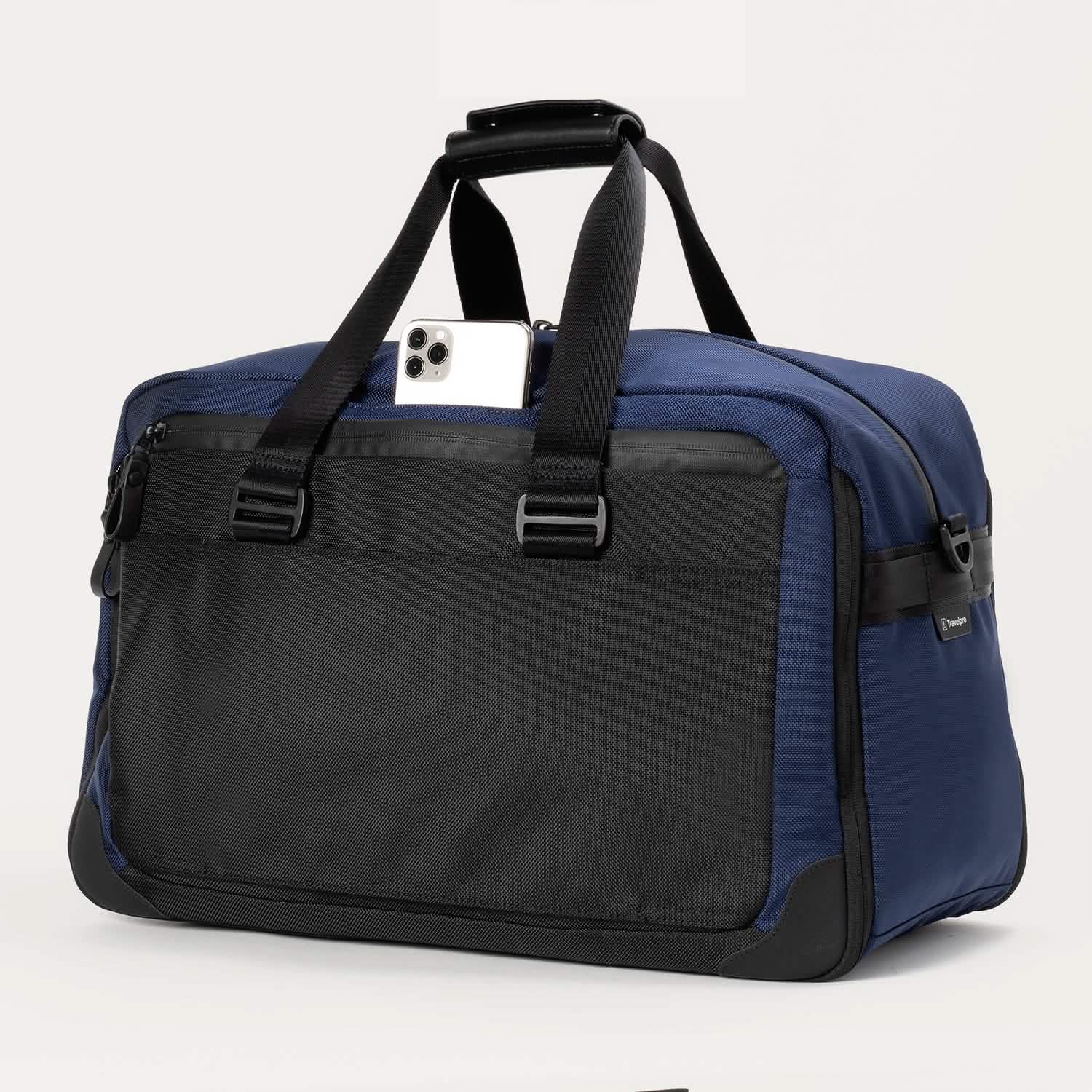 Rear view of the Travelpro® Altitude™ Double Expansion Duffel in Aviator Navy/Black, featuring a quick-access pocket with a smartphone partially inserted and sturdy dual handles.
