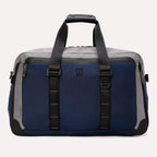 Rear view of the Travelpro® Altitude™ Double Expansion Duffel in Stellar Navy/Grey, featuring dual carry handles with reinforced stitching and a large exterior slip pocket holding a smartphone.
