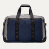 Rear view of the Travelpro® Altitude™ Double Expansion Duffel in Stellar Navy/Grey, featuring dual carry handles with reinforced stitching and a large exterior slip pocket holding a smartphone.
