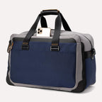 Rear view of the Travelpro® Altitude™ Double Expansion Duffel in Stellar Navy/Grey, featuring dual carry handles with reinforced stitching and a large exterior slip pocket holding a smartphone.
