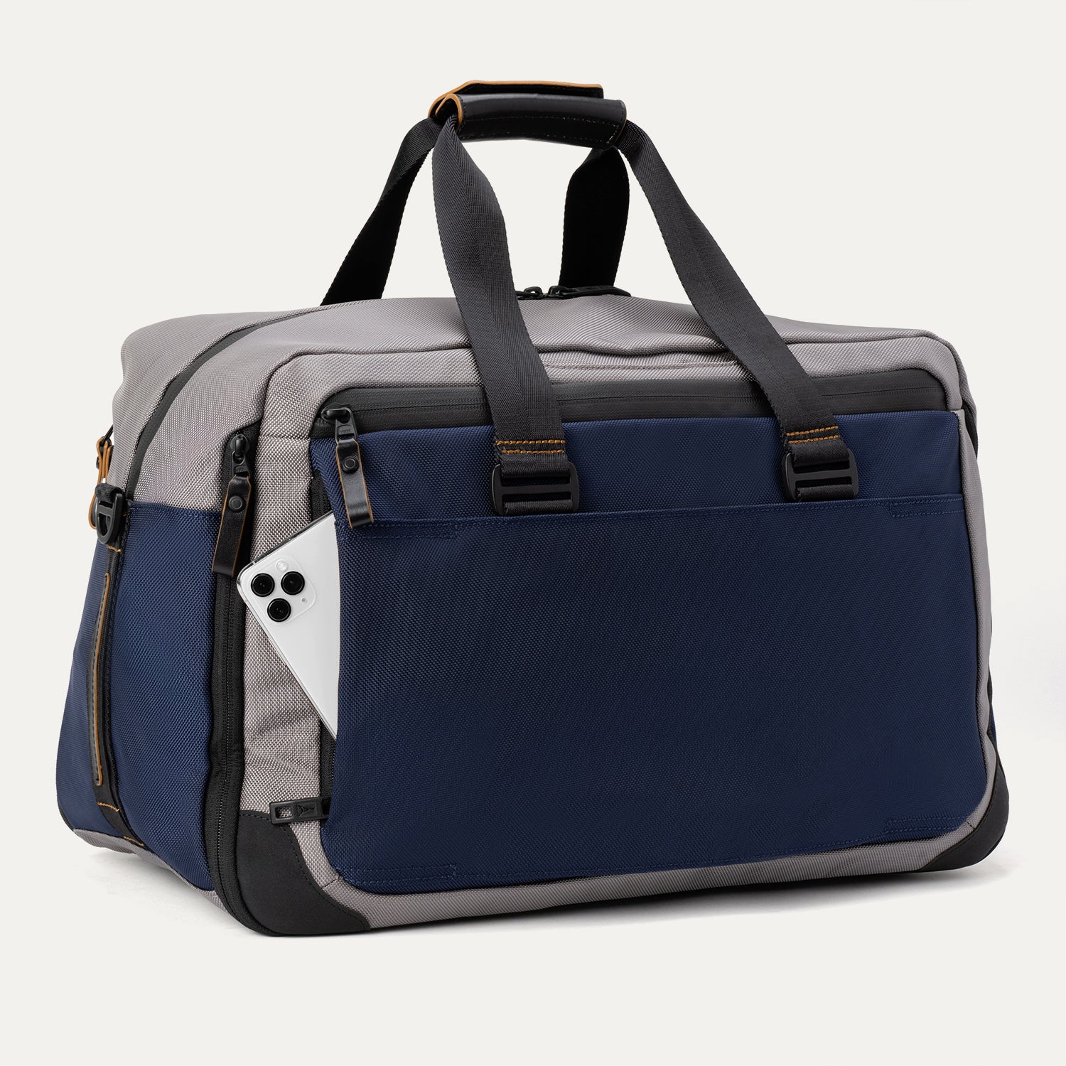 Slanted rear view of the Travelpro® Altitude™ Double Expansion Duffel in Stellar Navy/Grey, featuring dual carry handles with reinforced stitching and a exterior slip pocket holding a smartphone.
