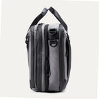 Side view of the Travelpro® Altitude™ Full Expansion Brief in Falcon Grey showing its compartments, zippers, and attachment points for a shoulder strap.

