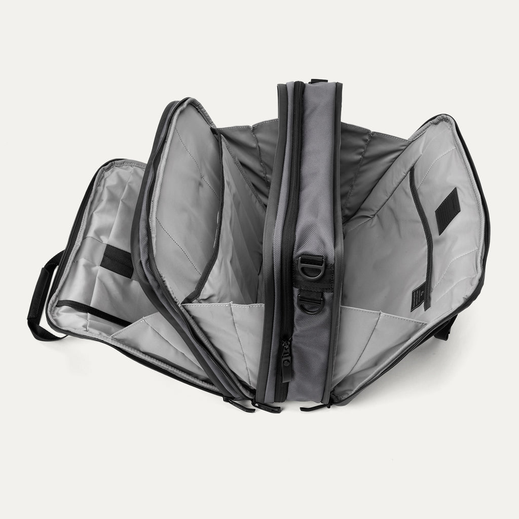 Open view of the Travelpro® Altitude™ Full Expansion Brief in Falcon Grey, showing three spacious compartments with divider panels and organizational sleeves.
