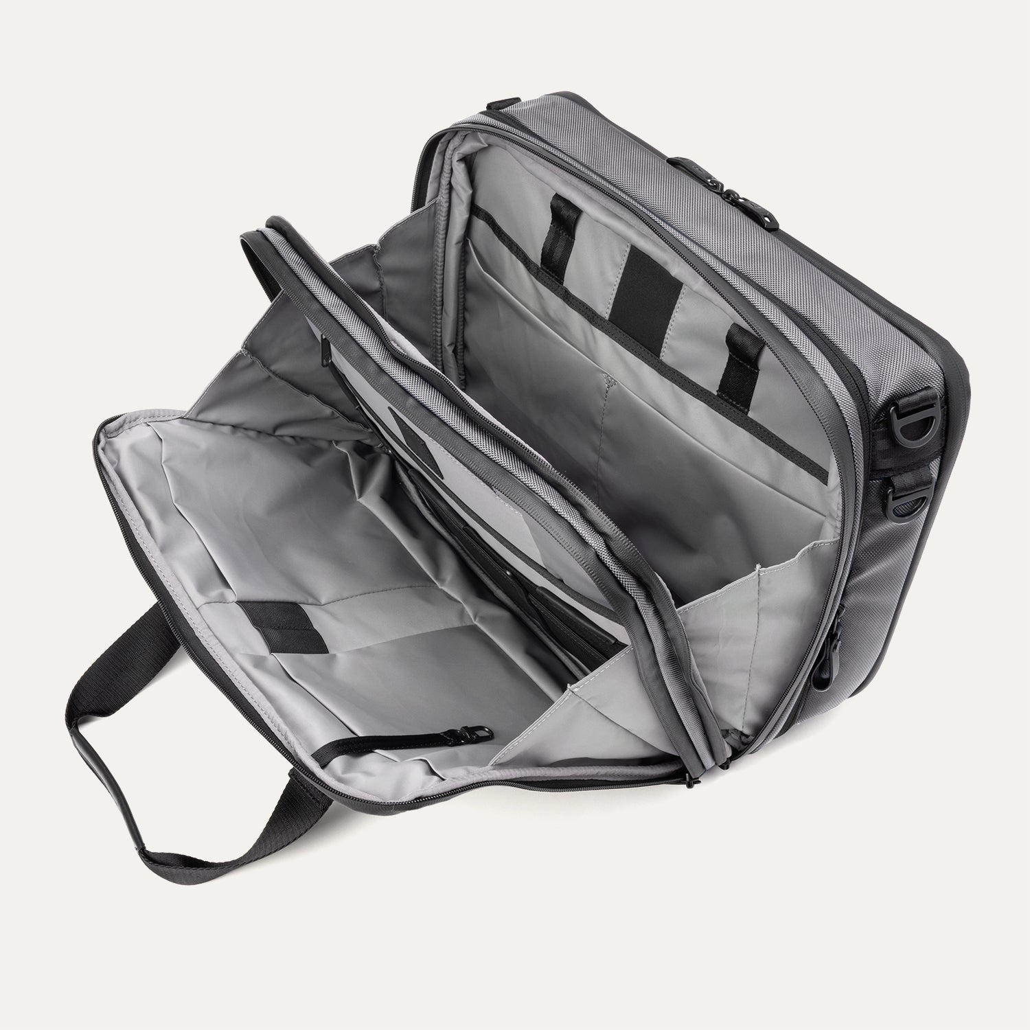 Open main compartment view of the Travelpro® Altitude™ Full Expansion Brief in Falcon Grey, showing dual sections with organizational pockets, zippered storage, and ample packing space.
