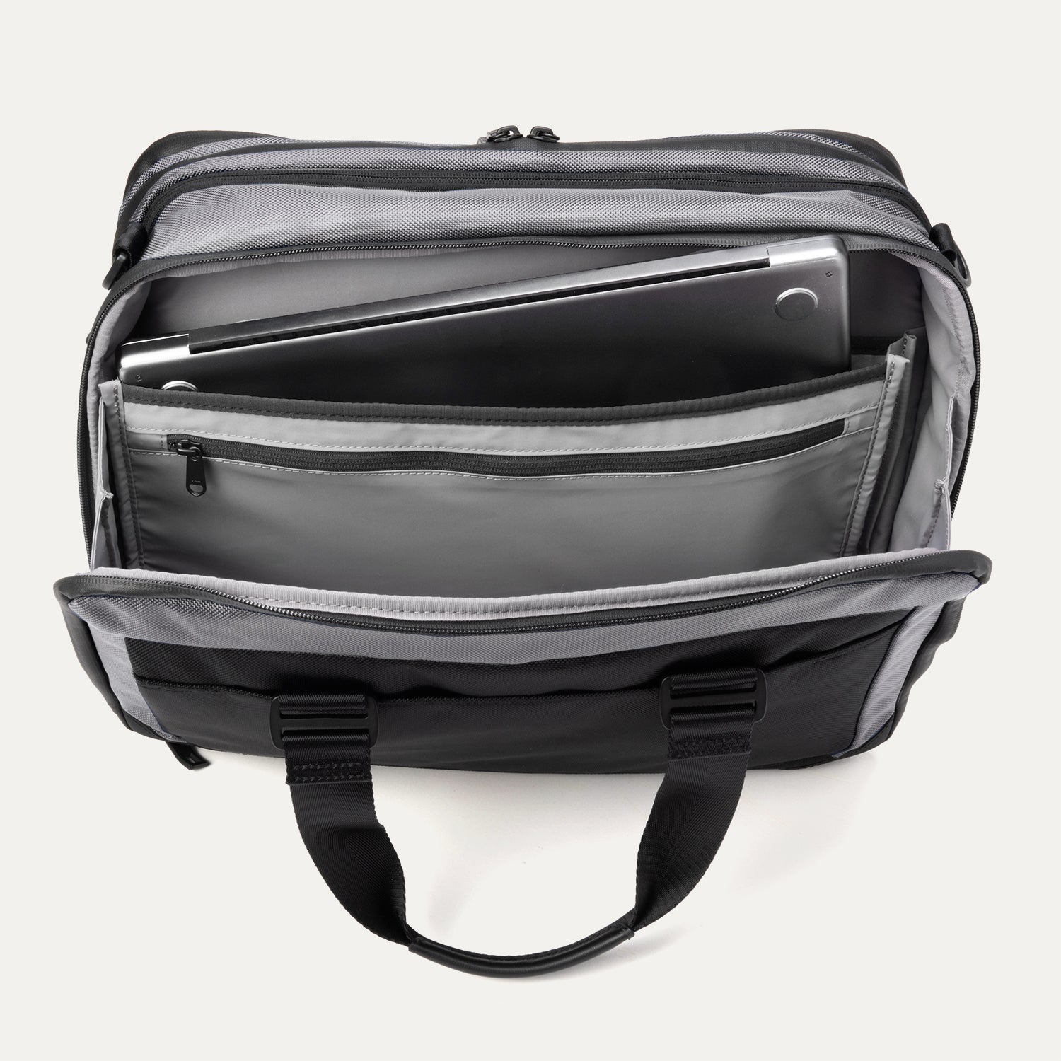 Rear compartment view of the Travelpro® Altitude™ Full Expansion Brief in Falcon Grey, showing the padded laptop sleeve holding a laptop, an additional tablet sleeve, and a zippered pocket for accessories.
