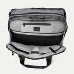 Open front pocket view of the Travelpro® Altitude™ Full Expansion Brief in Falcon Grey, showing an organized interior with a zippered pocket and multiple divided compartments for accessories.
