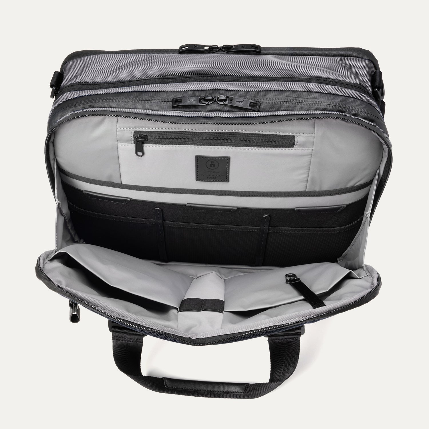 Open front pocket view of the Travelpro® Altitude™ Full Expansion Brief in Falcon Grey, showing an organized interior with a zippered pocket and multiple divided compartments for accessories.
