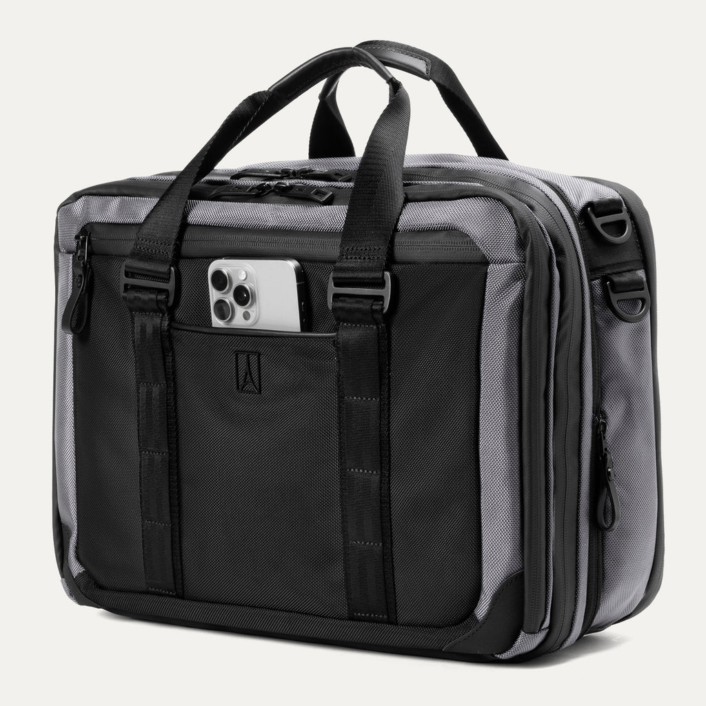 Slanted Front view of the Travelpro® Altitude™ Full Expansion Brief in Falcon Grey, featuring a smartphone in the front pocket, dual top handles, adjustable straps, and multiple zippered compartments.
