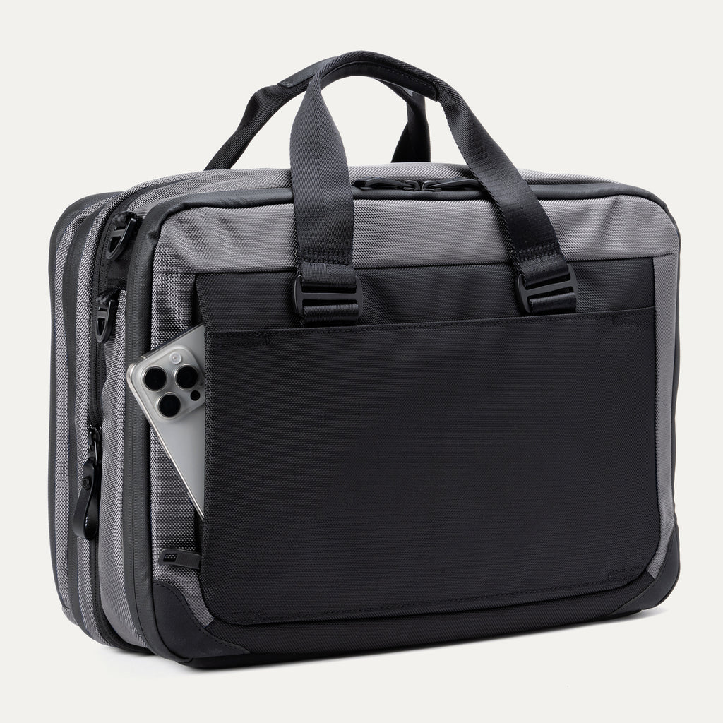 Rear view of the Travelpro® Altitude™ Full Expansion Brief in Falcon Grey, featuring a large exterior pocket holding a smartphone and dual top handles.
