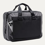 Rear view of the Travelpro® Altitude™ Full Expansion Brief in Falcon Grey, featuring a large exterior pocket holding a smartphone and dual top handles.
