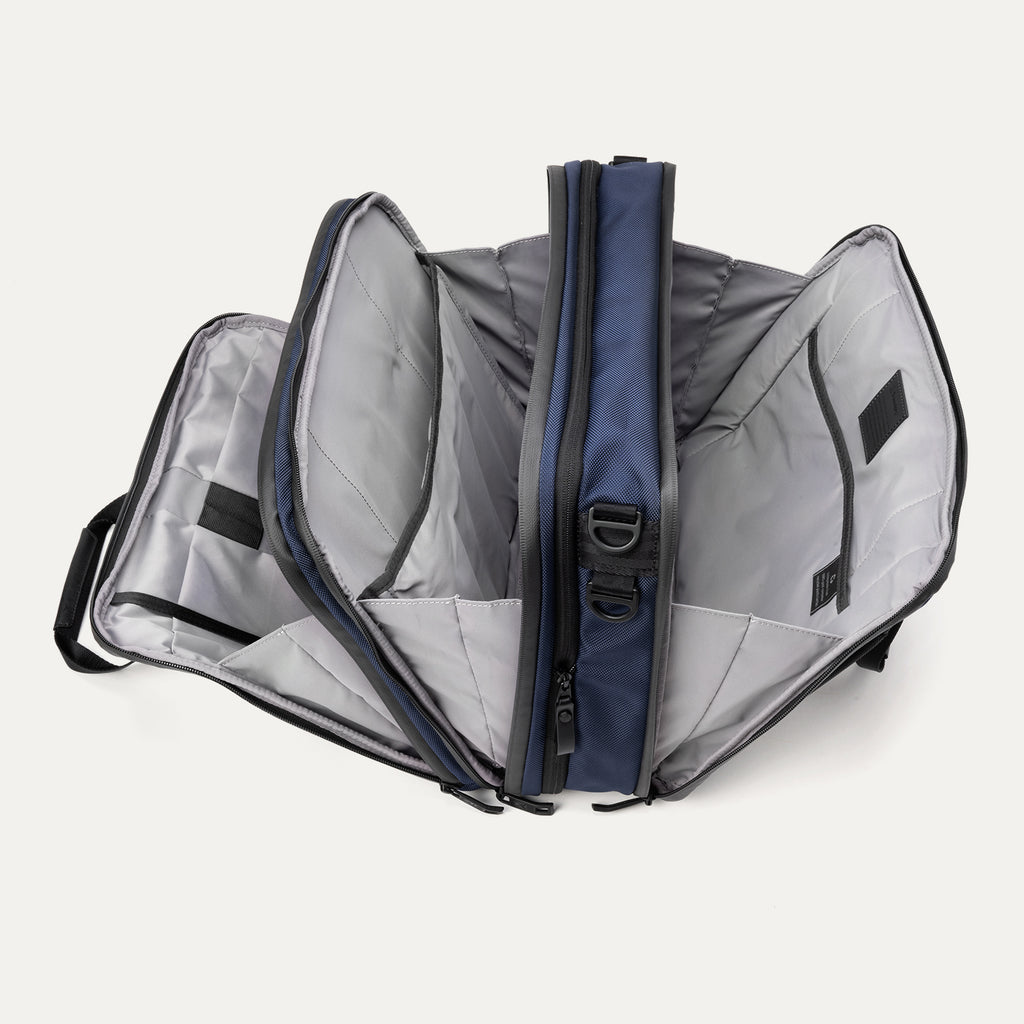 Open view of the Travelpro® Altitude™ Full Expansion Brief in Aviator Navy, showing three spacious compartments with divider panels and organizational sleeves.
