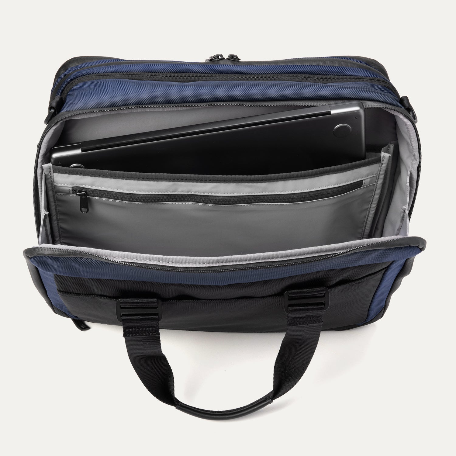 Top view of the Travelpro® Altitude™ Full Expansion Brief in Aviator Navy showing the rear compartment open, with a padded laptop sleeve and additional zippered and slip pockets for organized storage.