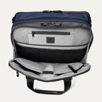 Open front pocket view of the Travelpro® Altitude™ Full Expansion Brief in Aviator Navy, showing an organized interior with a zippered pocket and multiple divided compartments for accessories.
