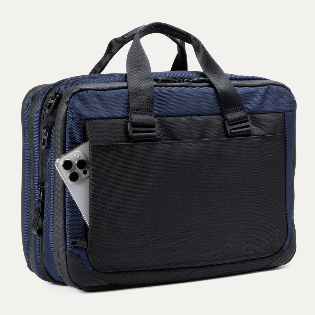 Rear view of the Travelpro® Altitude™ Full Expansion Brief in Aviator Navy, featuring a large slip pocket holding a smartphone for quick-access storage.
