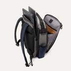 Interior view of the Travelpro Altitude Slim Expandable Laptop Backpack 20-24L in Stellar Navy and Grey, showcasing the spacious open main compartment with its signature orange lining and organized storage sleeves for a laptop and other essentials.