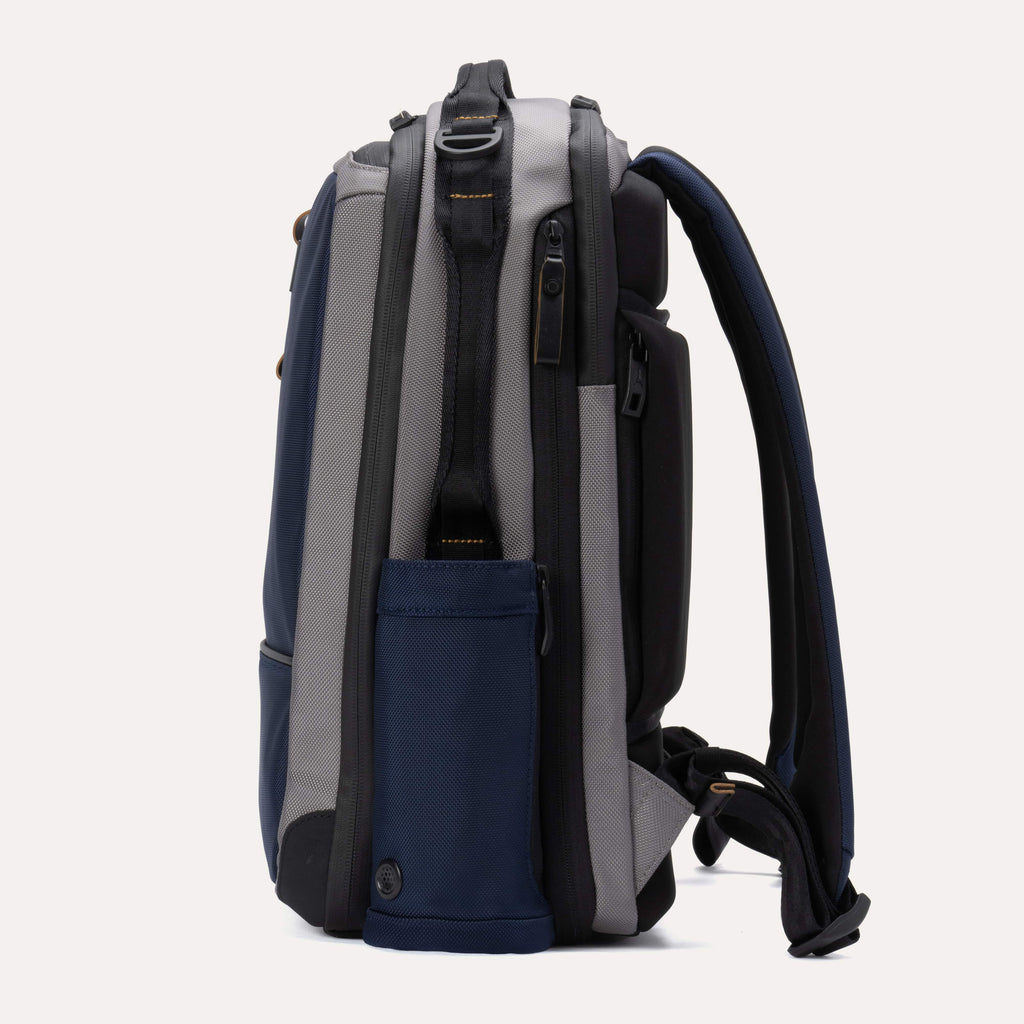 Side view of the Travelpro Altitude Slim Expandable Laptop Backpack 20-24L in Stellar Navy and Grey, showcasing its sleek, expandable profile and durable, water-resistant exterior construction.