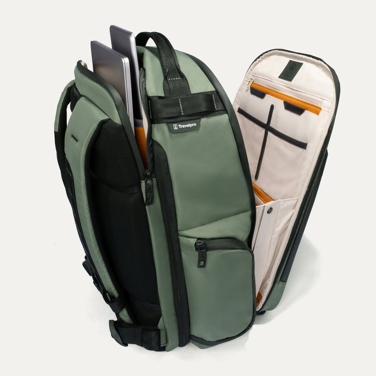 Side view of the Travelpro Altitude Large Expandable Laptop Backpack in Field Green, showing the open laptop compartment with computer, tablet, and interior pockets against a light background.