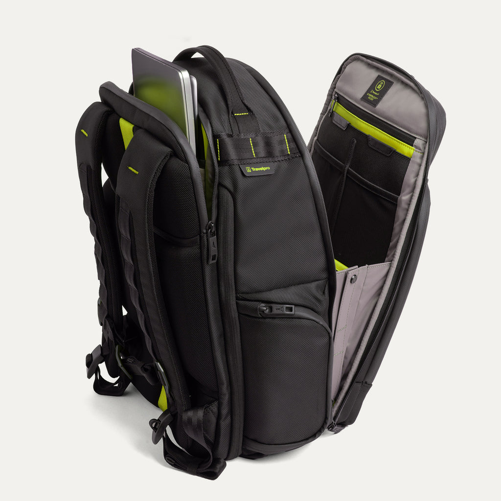 Three‑quarter rear view of the Travelpro Altitude Large Backpack in Neon Shadow, showing black textured exterior with neon yellow accents, open main compartment with gray lining, and multiple zippered pockets against a light background.