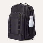 Three‑quarter front view of the Travelpro Altitude Large Backpack in Neon Shadow, showing black textured exterior with neon yellow stitching accents, multiple zippered compartments, and a white water bottle in the side pocket against a light background.