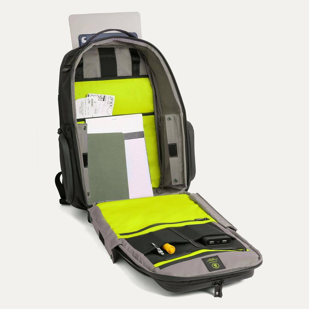 Front view of the Travelpro Altitude Large Backpack in Neon Shadow, showing fully open main compartment with laptop sleeve, organization pockets, and bright neon yellow interior panels against a light background.