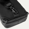 Close-up rear view of Travelpro Altitude Crossbody 6L in Black, showing D-rings and aluminum carabiner on back panel.
