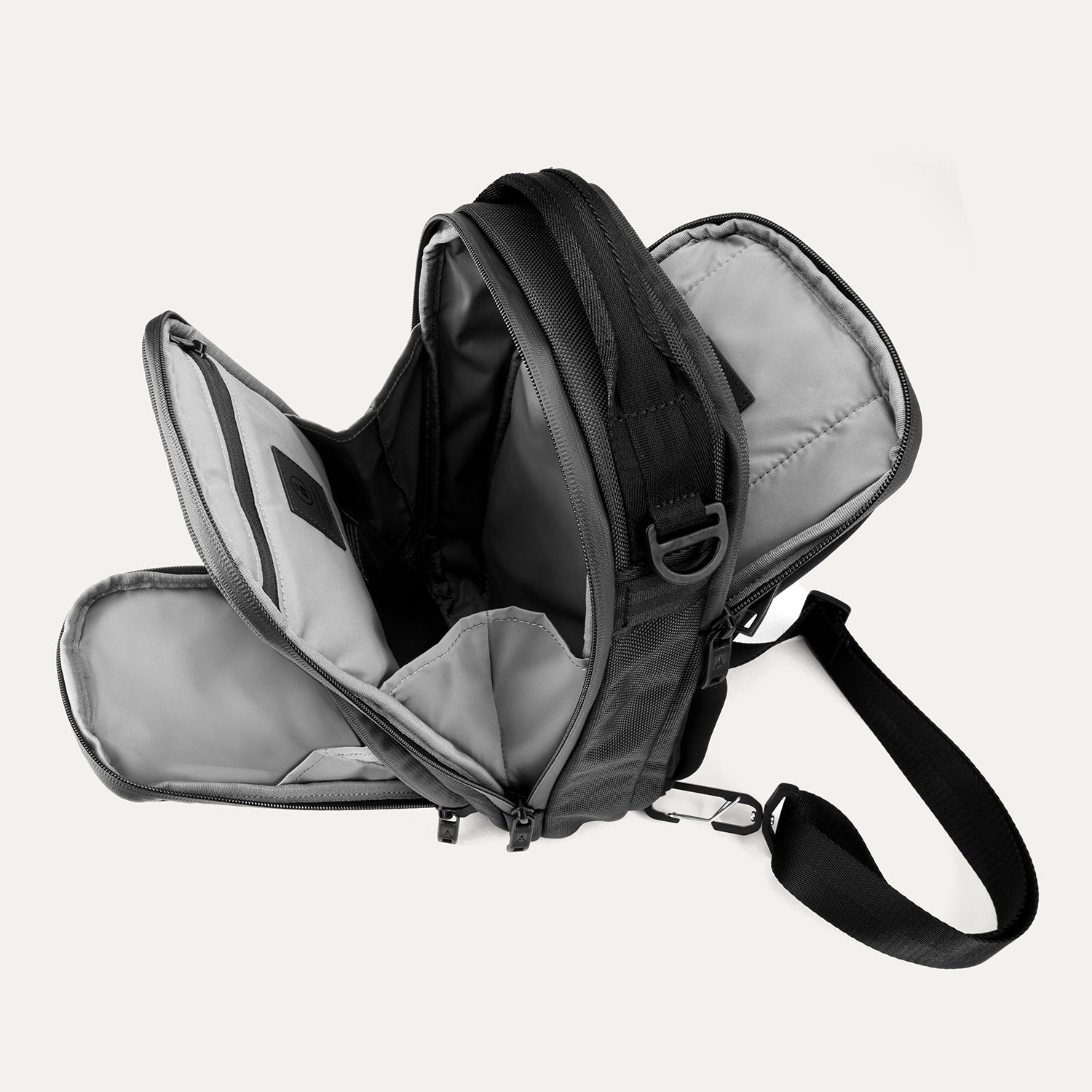 Interior view of Travelpro Altitude Crossbody 6L in Black, showing dual compartments with gray lining and tablet sleeve.
