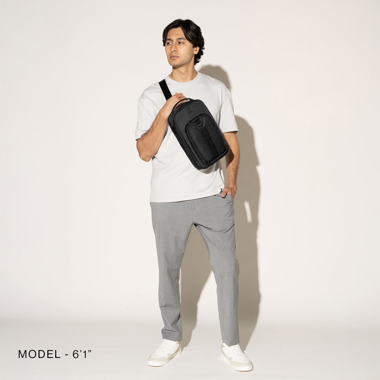 Person wearing a black crossbody over the shoulder on a white background