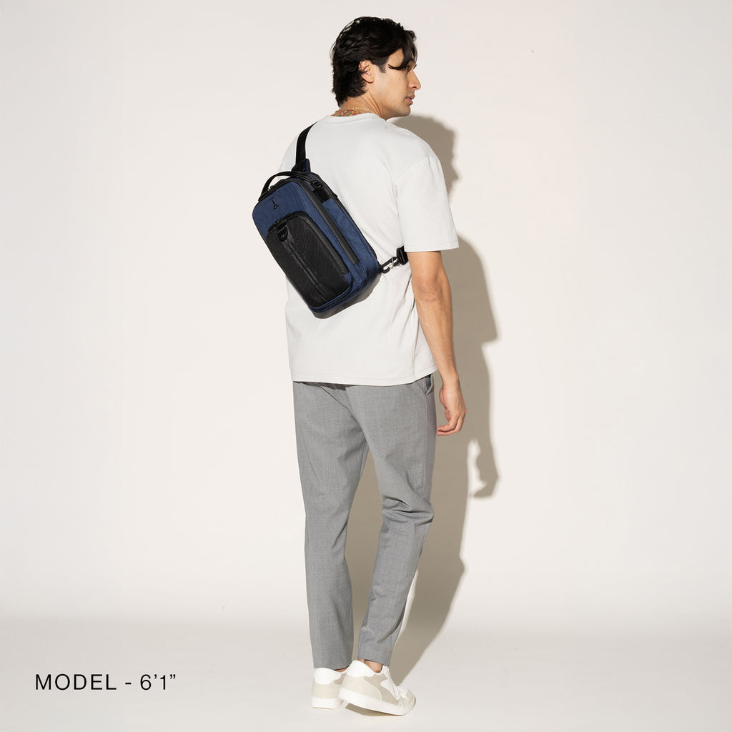 Person wearing a aviator navy crossbody over the shoulder on a white background