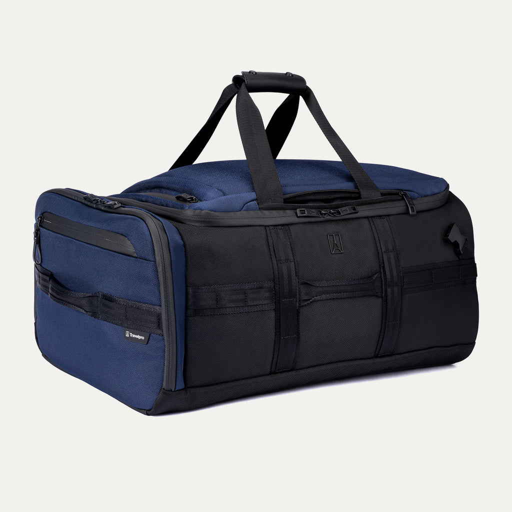 Angled front view of the Travelpro Altitude Convertible Duffel/Backpack in Aviator Navy, featuring multiple exterior pockets and dual top carry handles.

