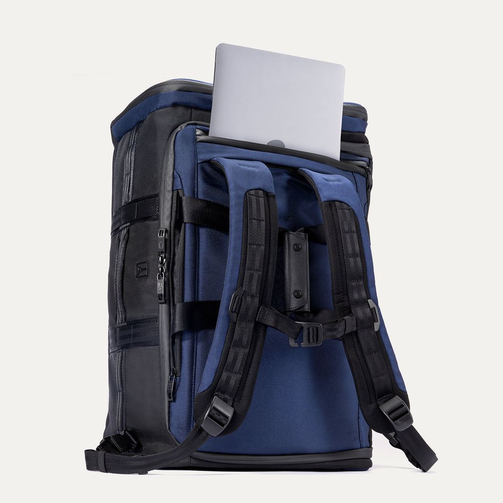Back view of the Travelpro Convertible Duffel/Backpack in Aviator Navy, featuring padded backpack straps and rear laptop pocket with laptop partially inserted.
