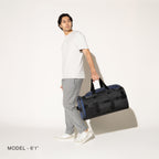 Person carrying a aviator navy convertible duffel on a white background