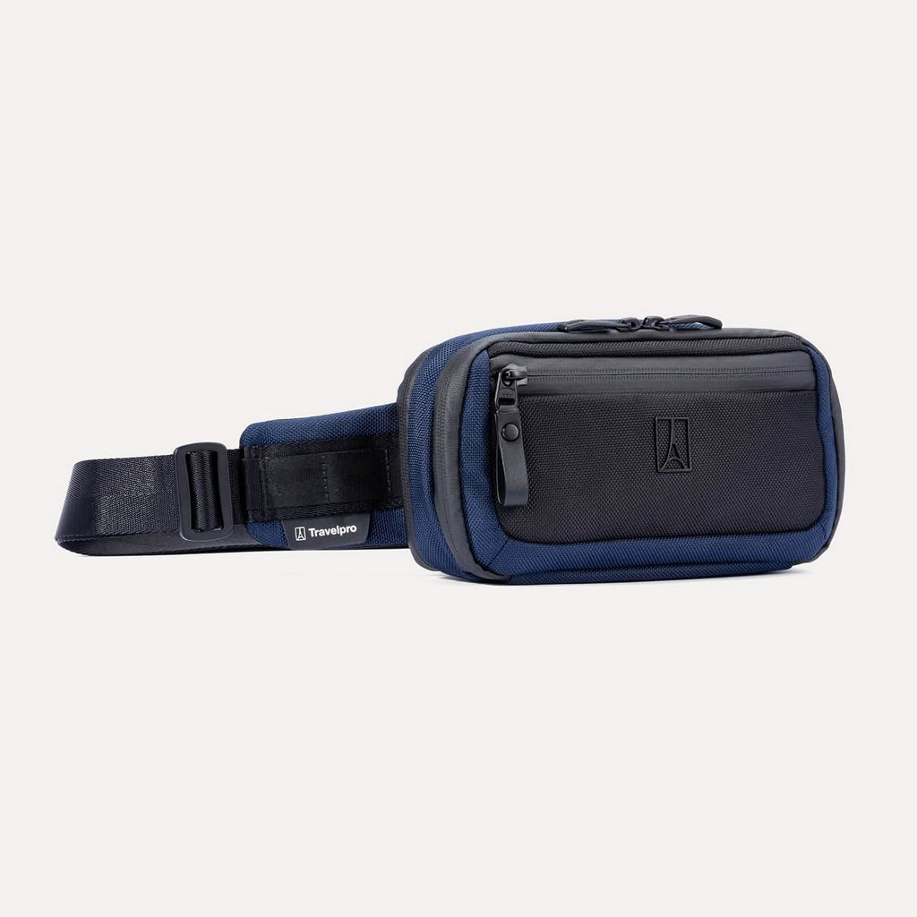 Front angled view of the Travelpro Altitude Sling 2L in Aviator Navy, showing dual zip compartments and exterior zip pocket.