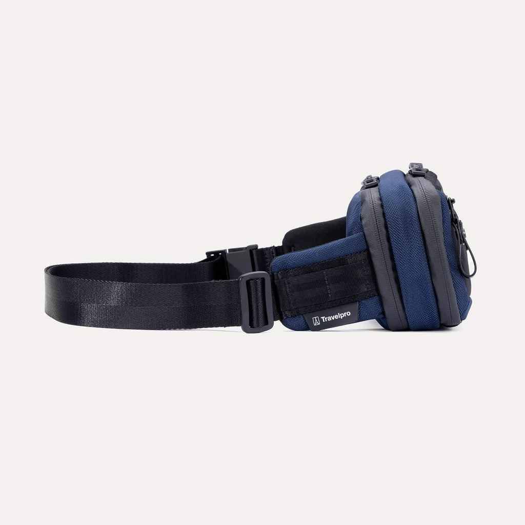 Side view of the Travelpro Altitude Sling 2L in Aviator Navy, showing Travelpro logo tab and adjustable buckle strap.
