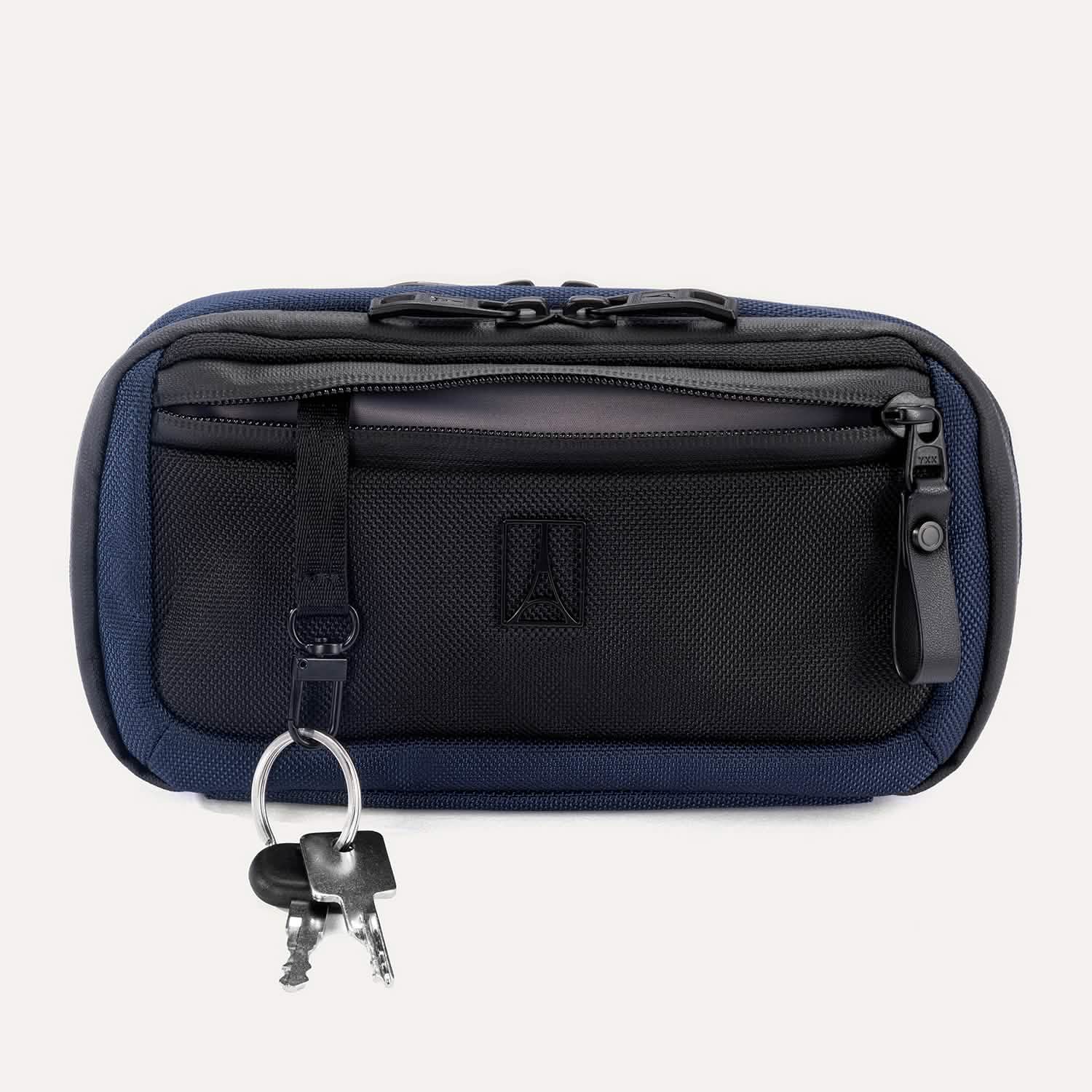 Travelpro Altitude Sling 2L in Aviator Navy, front view with key leash attached and zippered pocket visible.
