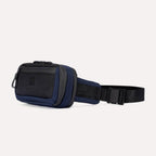 Slanted side view of Travelpro Altitude Sling 2L in Aviator Navy, showing adjustable strap and dual-zippered compartments.
