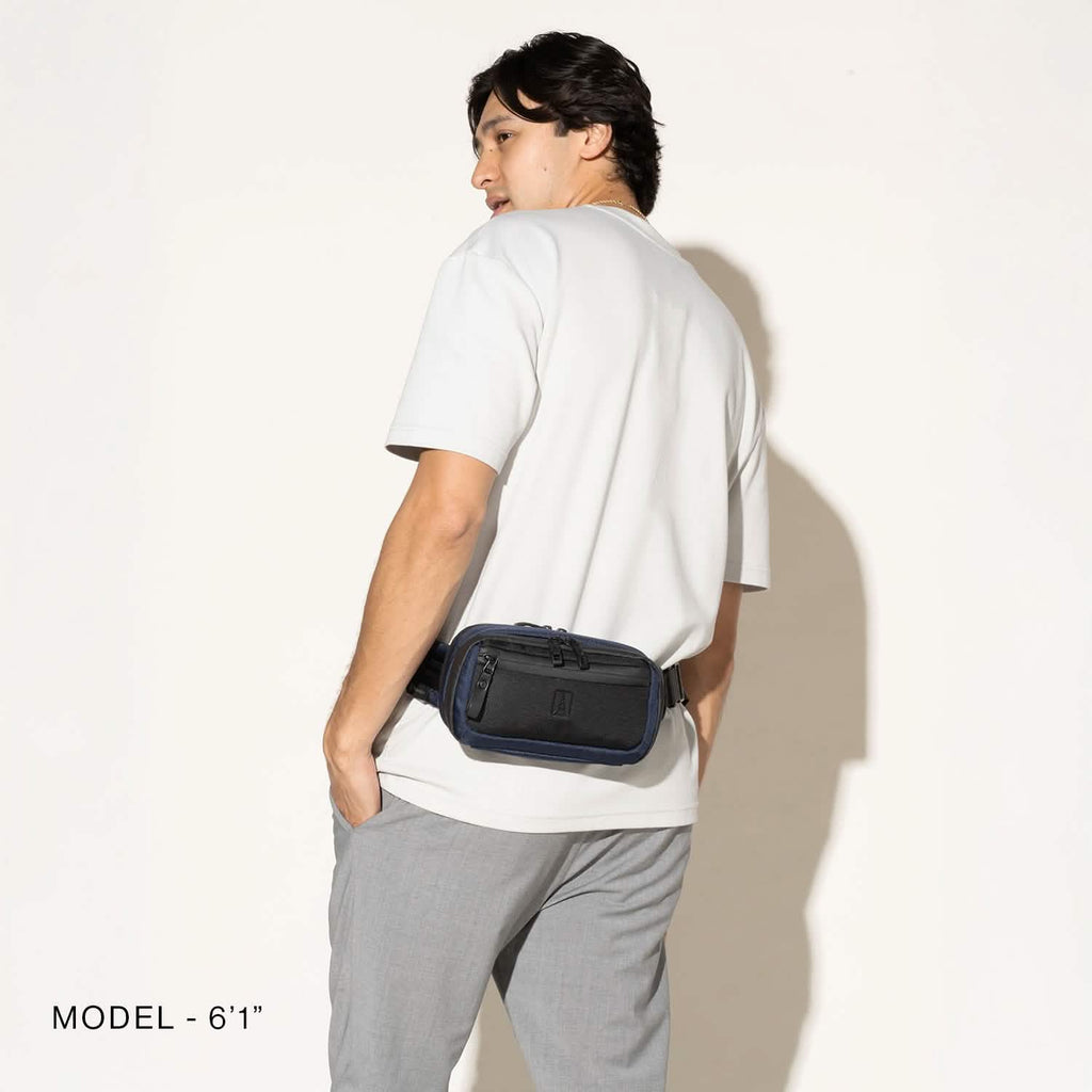 Person wearing a aviator navy sling around the waist on a white background
