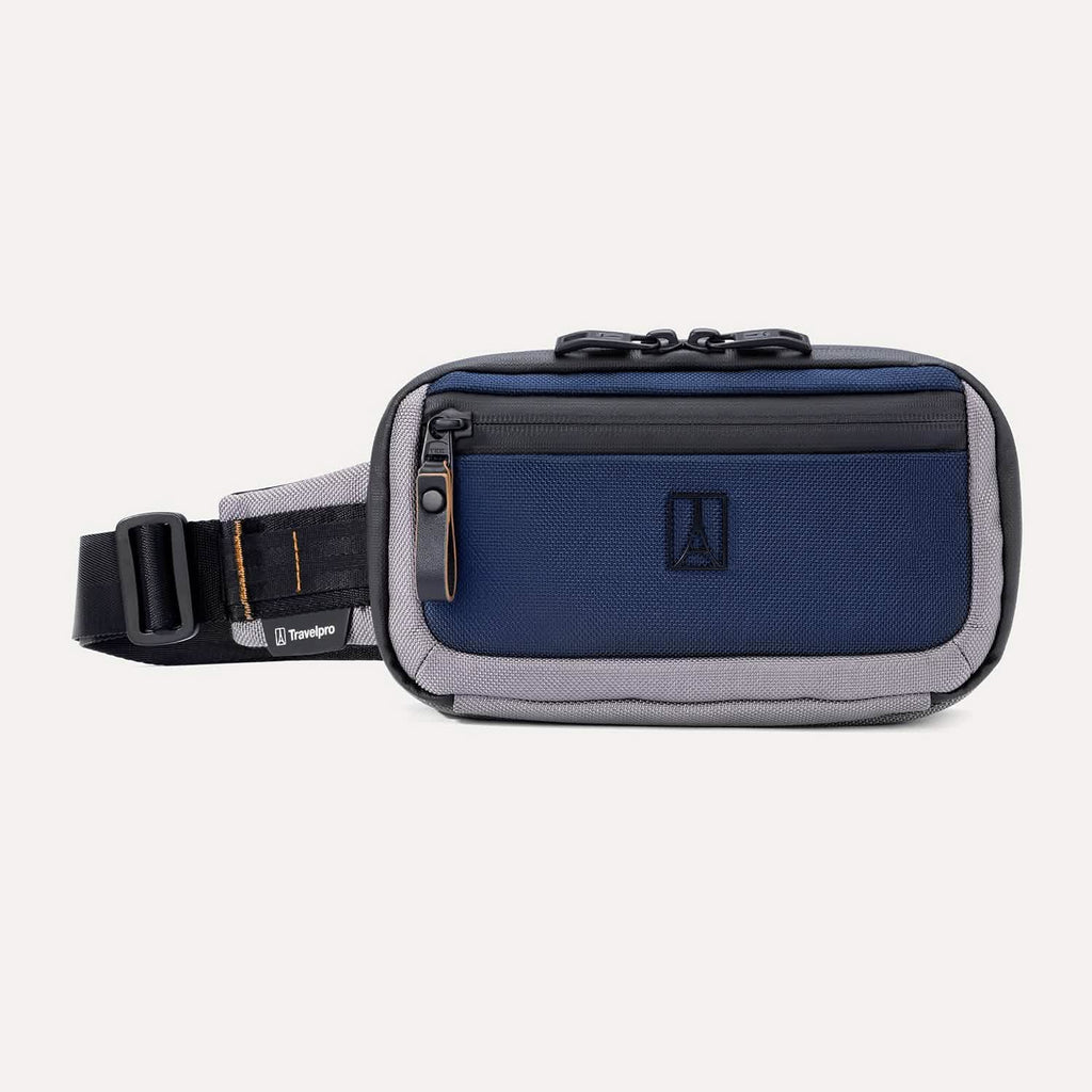 Front view of the Travelpro Altitude Sling 2L in Stellar Navy/Grey, showing front zip pocket, logo, and adjustable waist strap.
