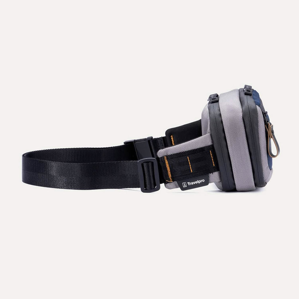 Side view of the Travelpro Altitude Sling 2L in Stellar Navy/Grey, showing the buckle closure and stitched brand tag.
