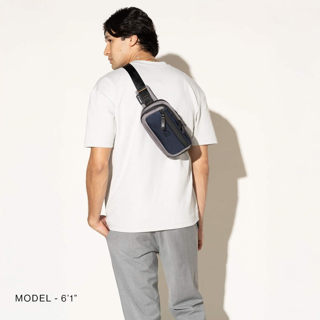 Person wearing a stellar navy sling over the shoulder on a white background