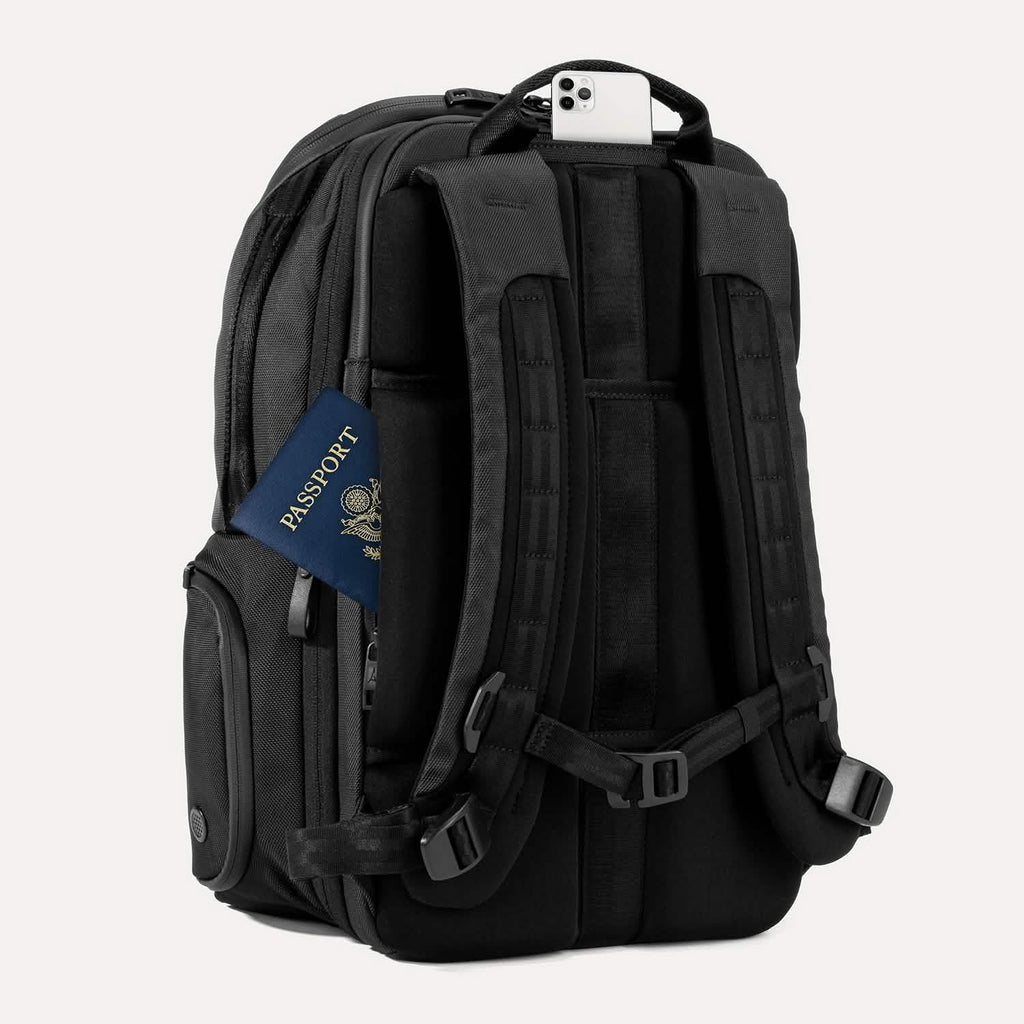 Rear view of Travelpro Altitude All-Purpose Laptop Backpack in Jet Black, featuring padded straps and QuickSlip Pocket with phone.
