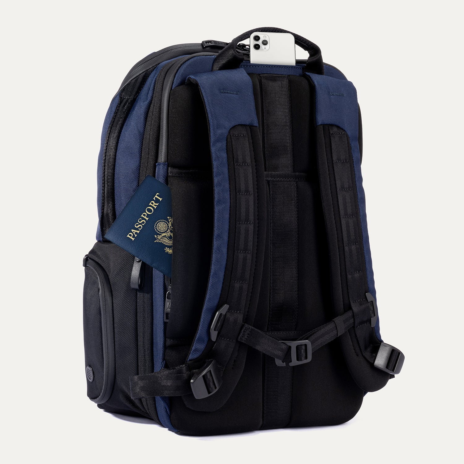 Slanted Rear view of Travelpro Altitude All-Purpose Laptop Backpack in Aviator Navy, showing QuickSlip Pocket with phone and hidden passport pocket.
