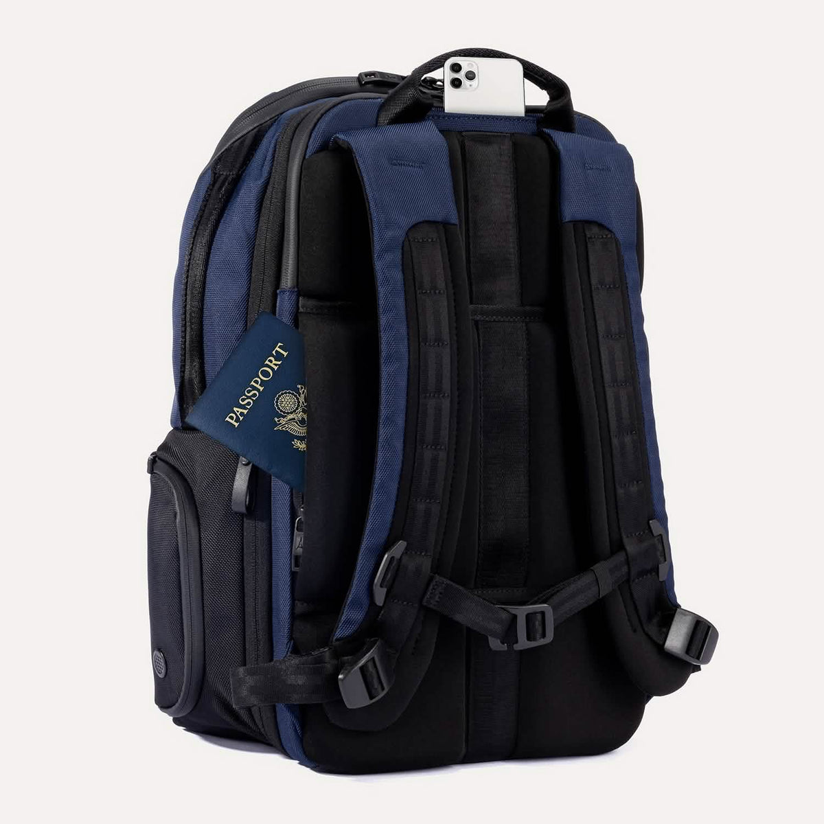 Slanted Rear view of Travelpro Altitude All-Purpose Laptop Backpack in Aviator Navy, showing QuickSlip Pocket with phone and hidden passport pocket.
