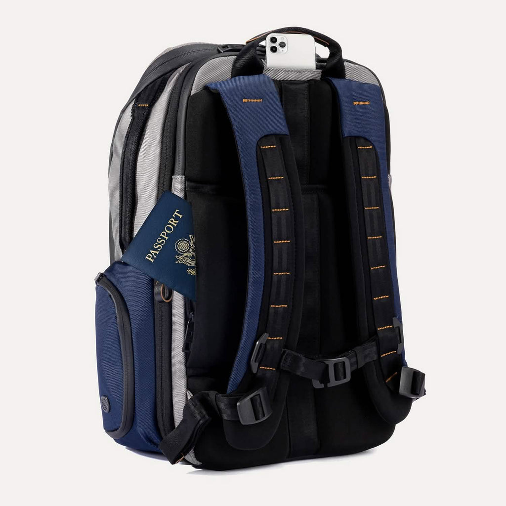 Rear angled view of the Travelpro Altitude All-Purpose Backpack in Stellar Navy/Grey, showing padded straps and back pocket access.
