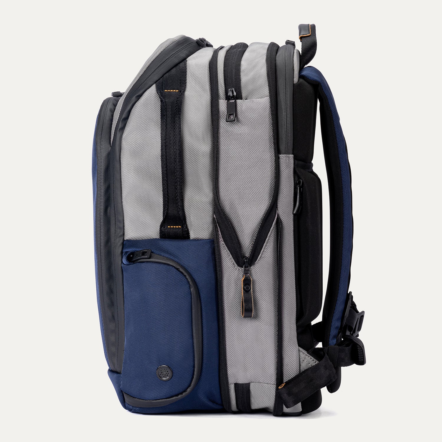 Side view of expanded Travelpro Altitude All-Purpose Backpack in Stellar Navy/Grey, showing exterior side compartments.
