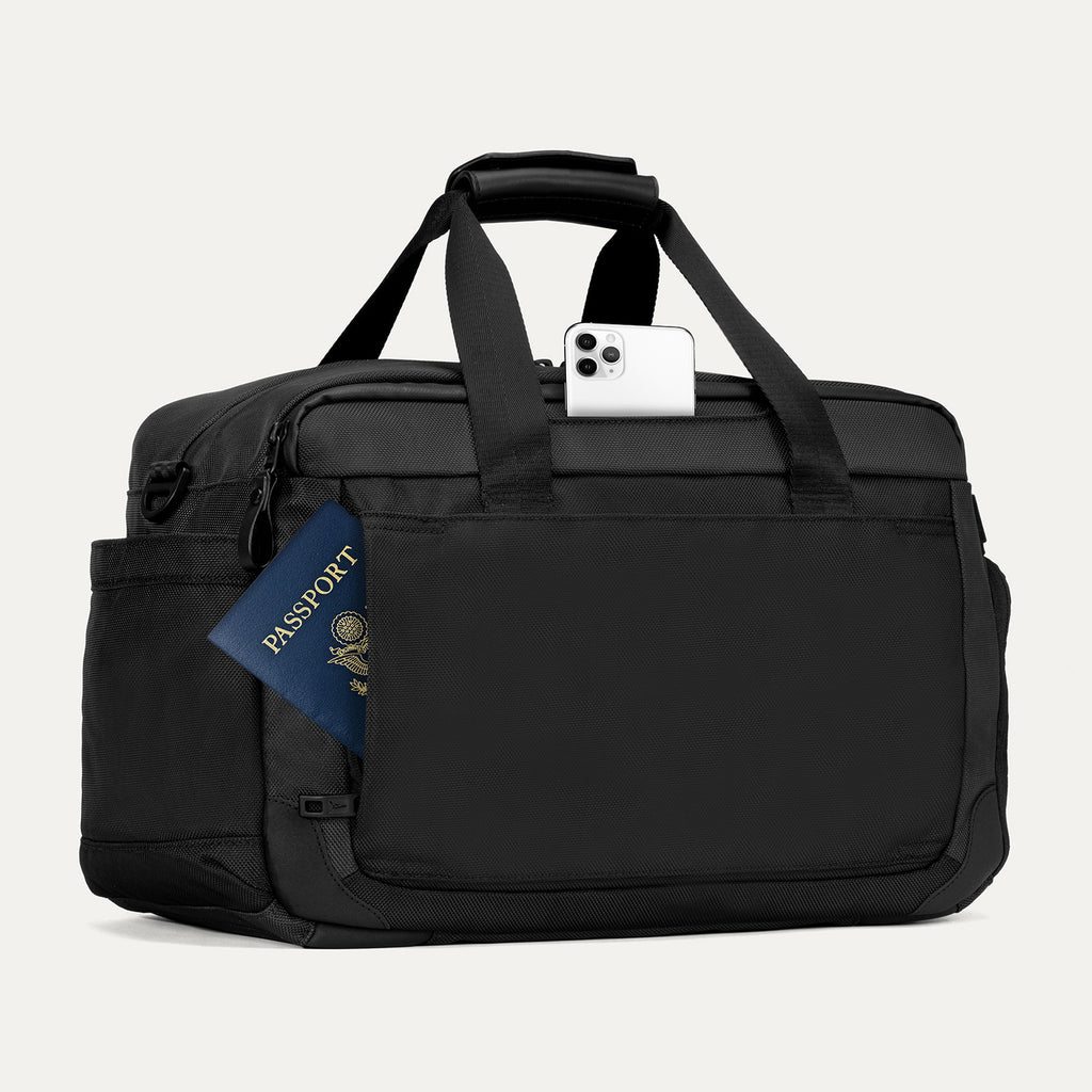Rear view of the Travelpro Altitude Day-to-Day Duffel in Jet Black, showing phone and passport in the quick-access pocket.
