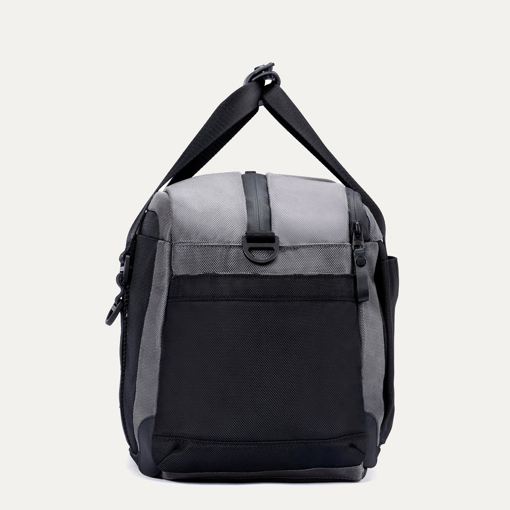 Side view of the Travelpro Altitude Day-to-Day Duffel in Falcon Grey, showing the adjustable shoulder strap and end pocket.
