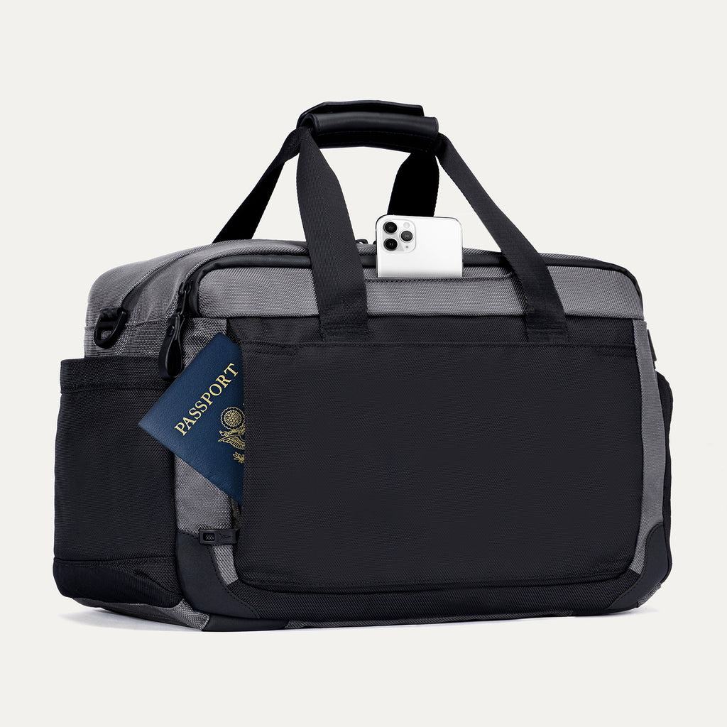 Rear view of the Travelpro Altitude Day-to-Day Duffel in Falcon Grey, showing passport and phone in quick-access exterior pocket.
